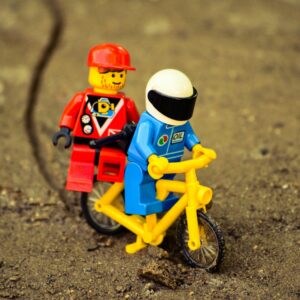 lego mini figure riding yellow bicycle